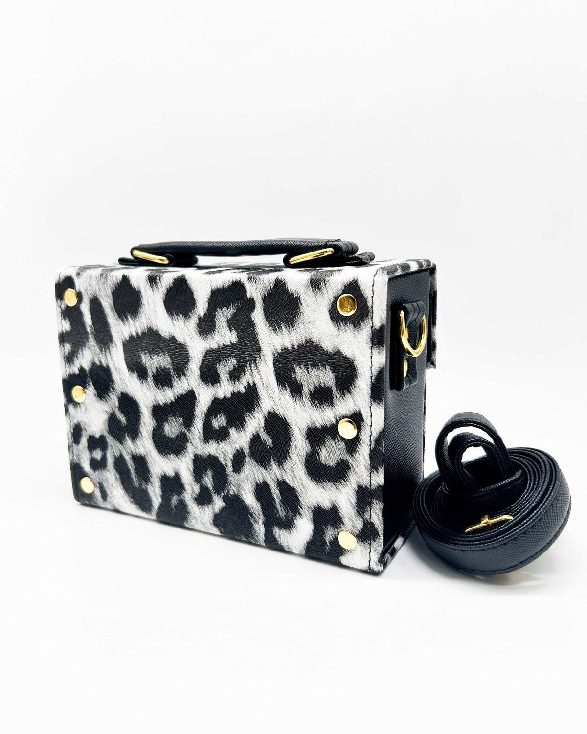 Back view, black and white animal print vegan leather handbag with a gold buckle clasp and adjustable strap.