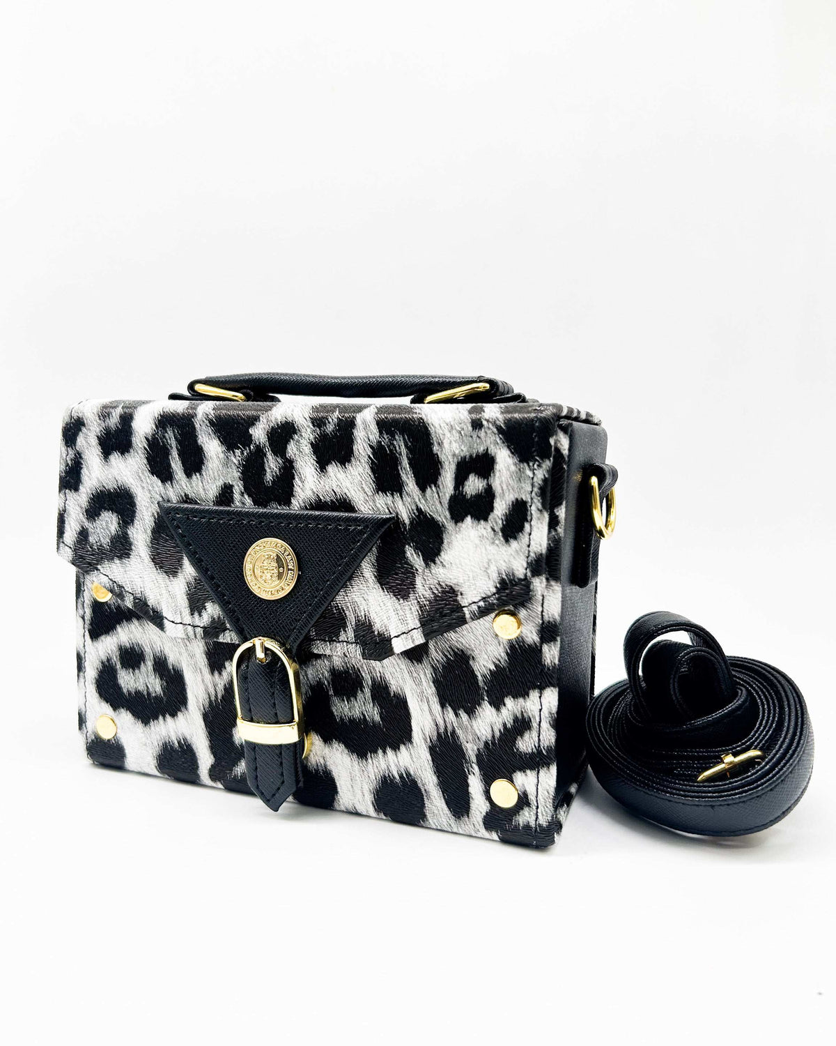 Black and white animal print vegan leather handbag with a gold buckle clasp and adjustable strap.