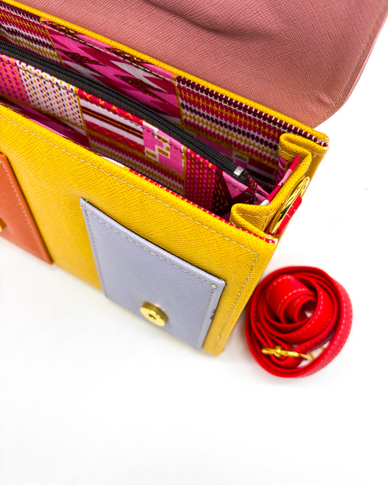 Inside view, orange vegan leather handbag or crossbody bag, with African Wax fabric inlay, two gold buckles and a magnetic clasp.
