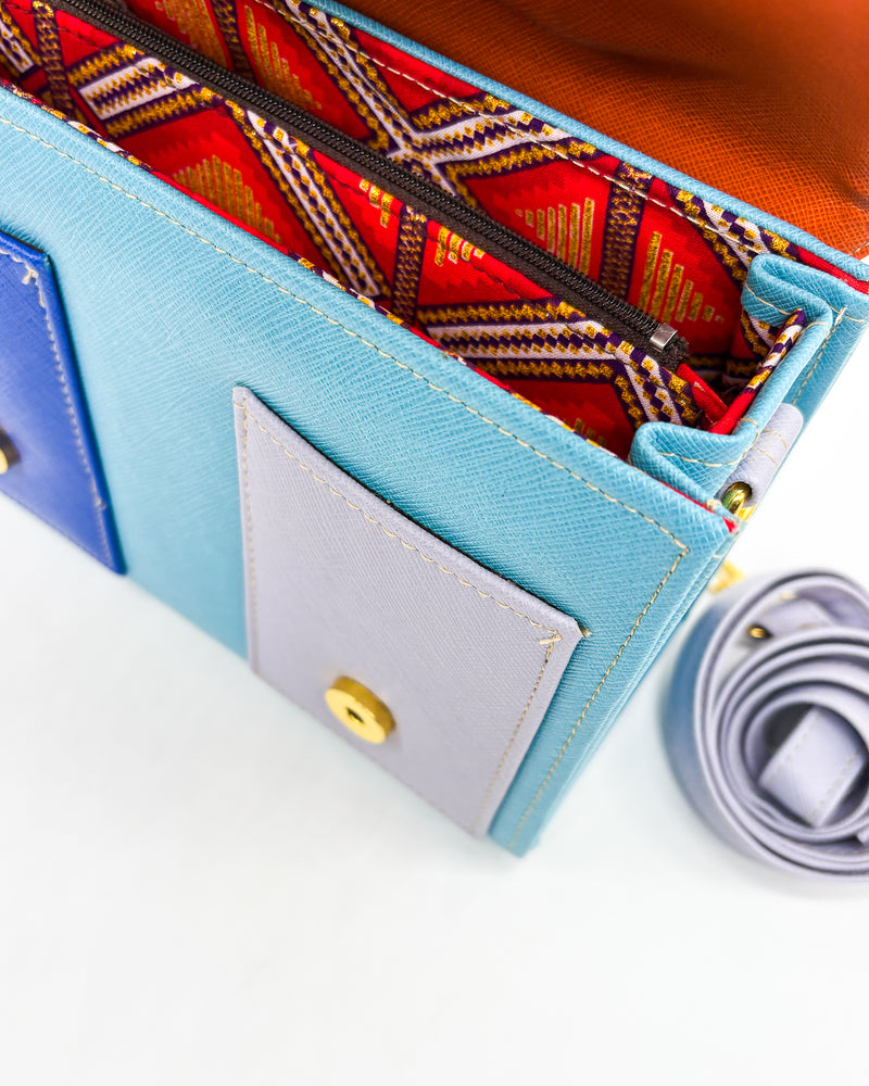 Inside view, teal vegan leather handbag or crossbody bag, with African Wax fabric inlay, two gold buckles and a magnetic clasp.