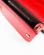 Inside view, red vegan leather handbag with blue and yellow African Gold Wax fabric inlay, gold magnetic clasp and adjustable strap.