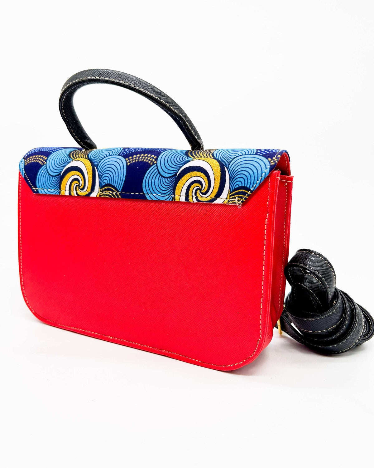 Back view, red vegan leather handbag with blue and yellow African Gold Wax fabric inlay, gold magnetic clasp and adjustable strap.