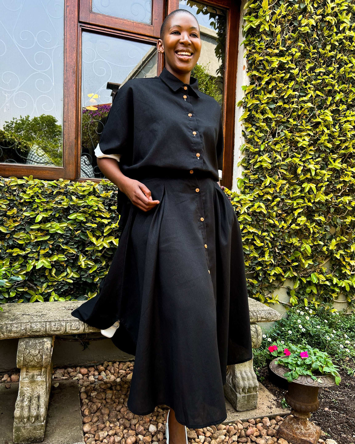 Smiling African woman wearing a Zandi Skirt in black.