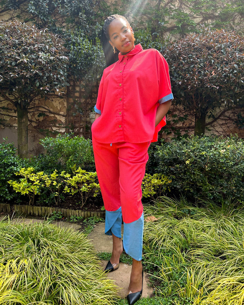 African woman wearing Dr Pachanga two-tone Kate Pants in pink and blue, with hands in her pockets.