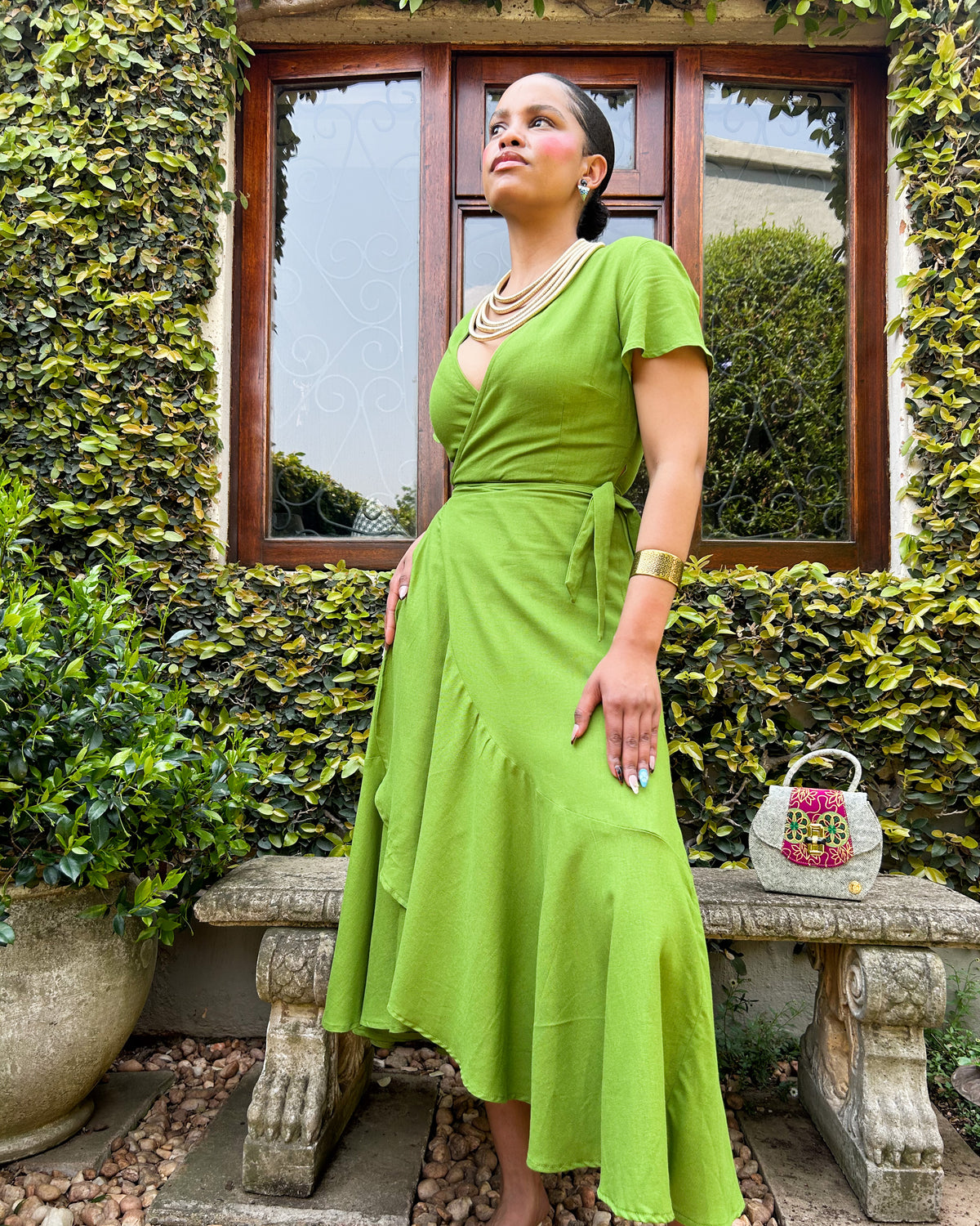 African woman wearing a bright grass green Spring edition Christine dress.