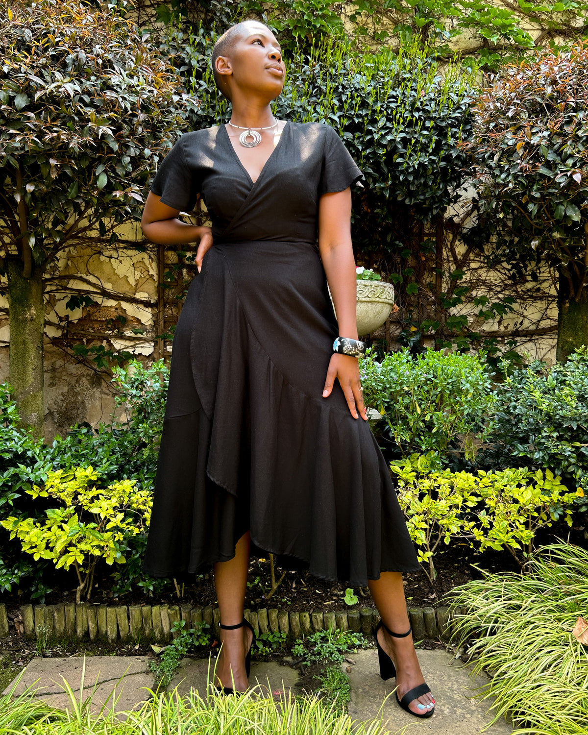 African woman wearing a black Christine dress.