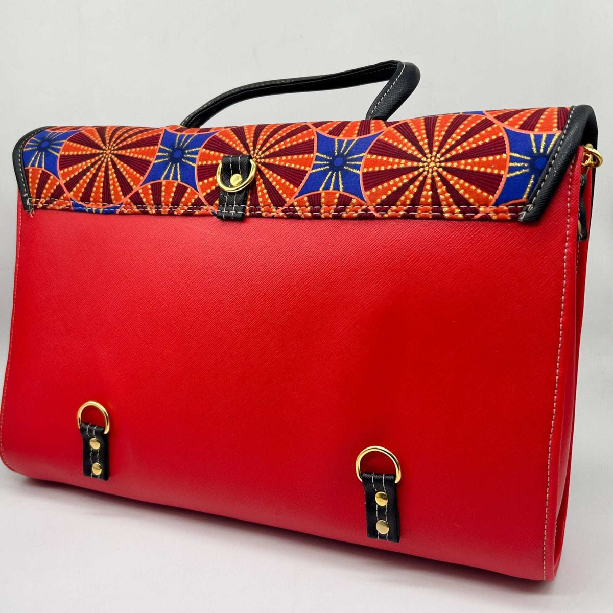 Back angle, red vegan leather handbag, backpack or crossbody bag with blue and orange African wax fabric inlay and two gold buckled clasps.