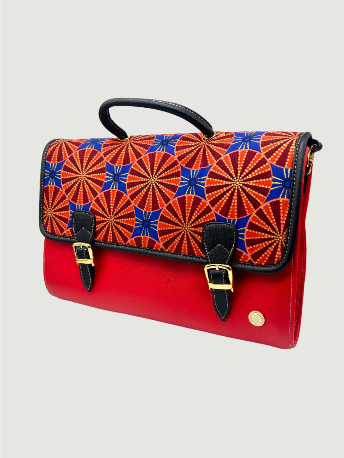 Red vegan leather handbag, backpack or crossbody bag with blue and orange African wax fabric inlay and two gold buckled clasps.