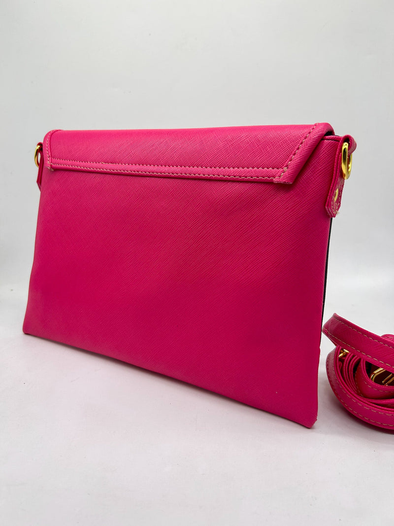 Back view, two-tone pink and black textured vegan leather clutch bag with magnetic clasp and adjustable strap.