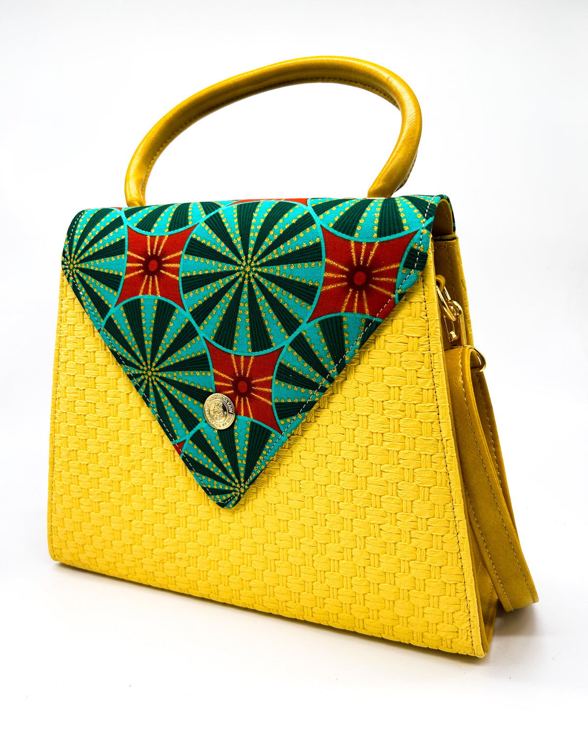 Yellow textured vegan leather handbag with green and red African Gold Wax fabric inlay, a magnetic clasp and adjustable strap.