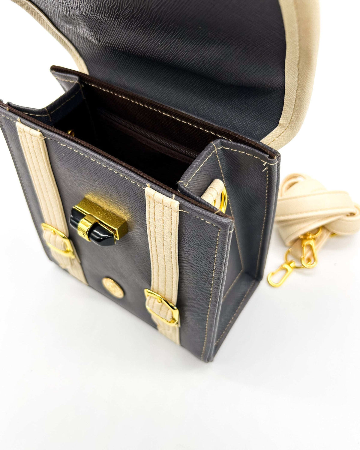 Inside view, black vegan leather handbag, backpack or crossbody bag with aquamarine African wax fabric inlay, two gold buckled clasps and a twist-lock.