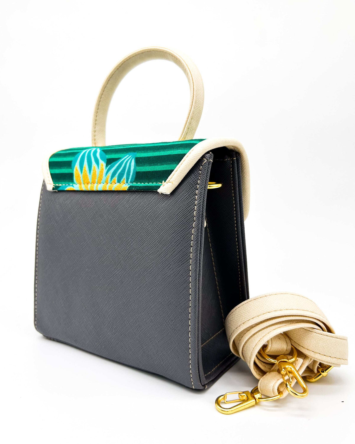 Back view, black vegan leather handbag, backpack or crossbody bag with aquamarine African wax fabric inlay, two gold buckled clasps and a twist-lock.