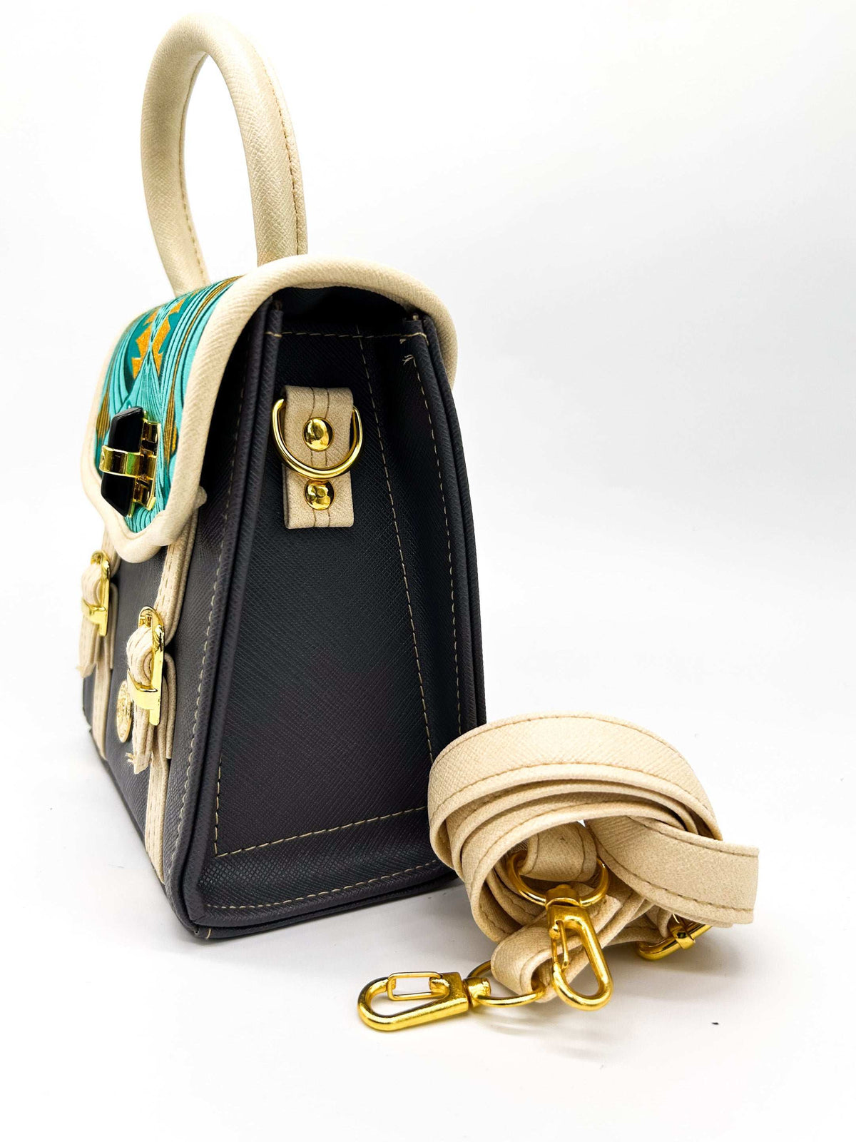 Side view, black vegan leather handbag, backpack or crossbody bag with aquamarine African wax fabric inlay, two gold buckled clasps and a twist-lock.