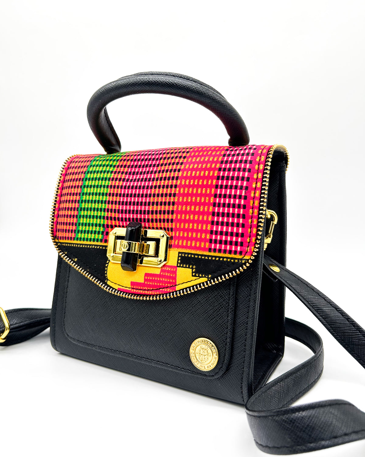 Black vegan leather handbag with colourful African Gold Wax fabric inlay, a twist-lock clasp and adjustable strap.