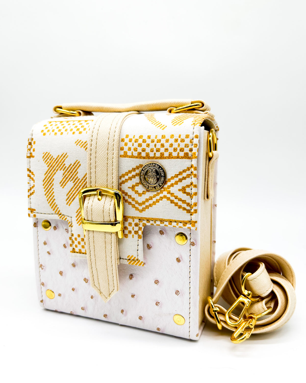 White vegan leather handbag with white and gold African Gold Wax fabric inlay, a single gold buckle, magnetic clasp and adjustable strap.