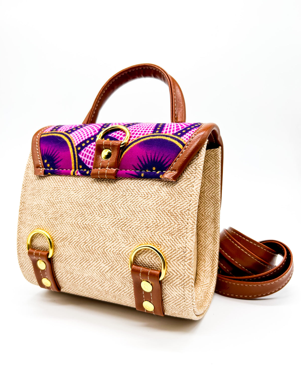 Back angle, vegan leather handbag or backpack with pink and yellow African wax fabric inlay and two buckled clasps.