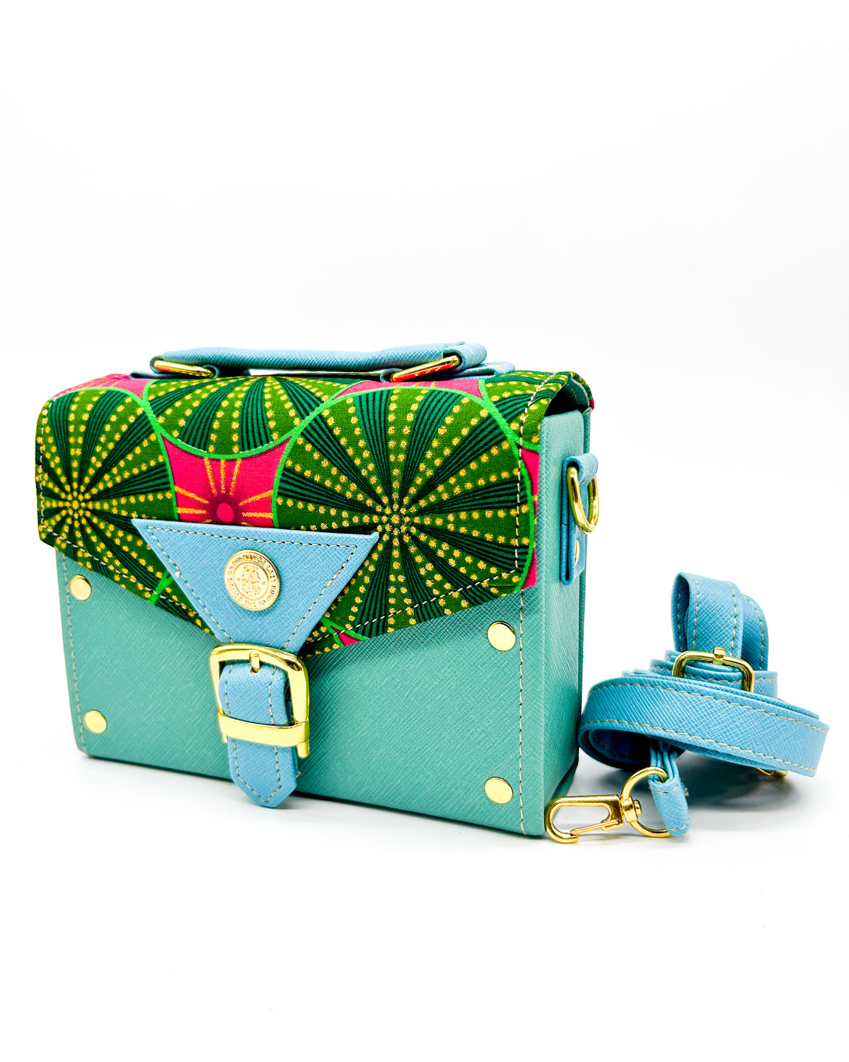 Teal vegan leather handbag or crossbody bag with baby blue accents, red and green African wax fabric inlay, a gold buckled clasp and adjustable strap.