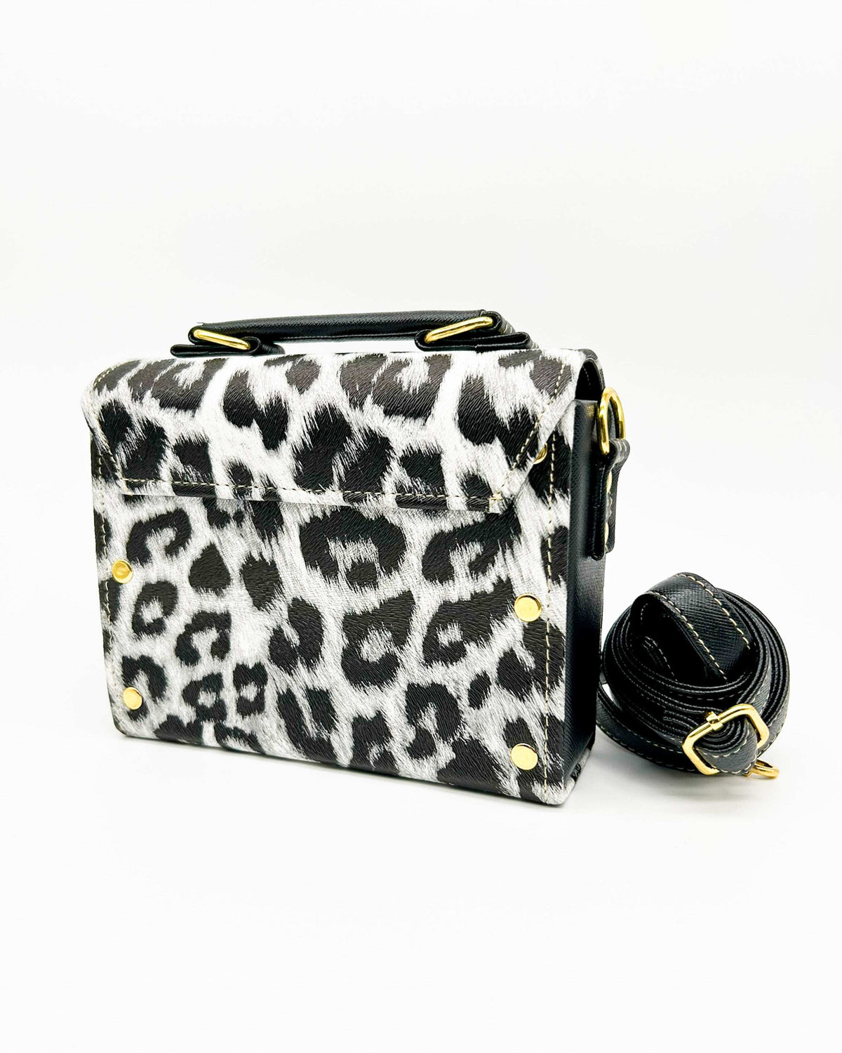 Back view, black and white leopard print vegan leather handbag, backpack or crossbody bag with two gold buckled clasps.