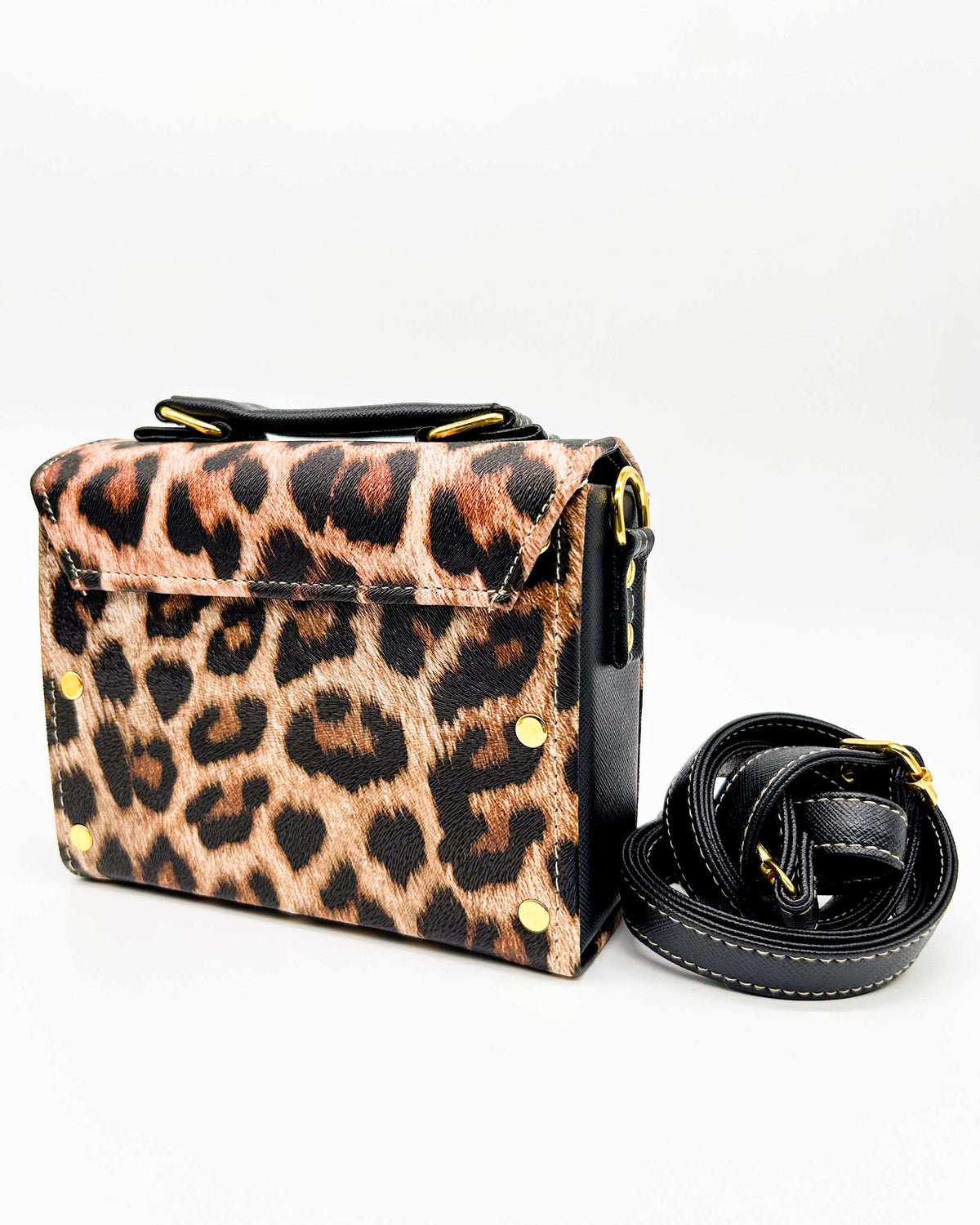 Back view, brown and black leopard print vegan leather handbag, backpack or crossbody bag with two gold buckled clasps.