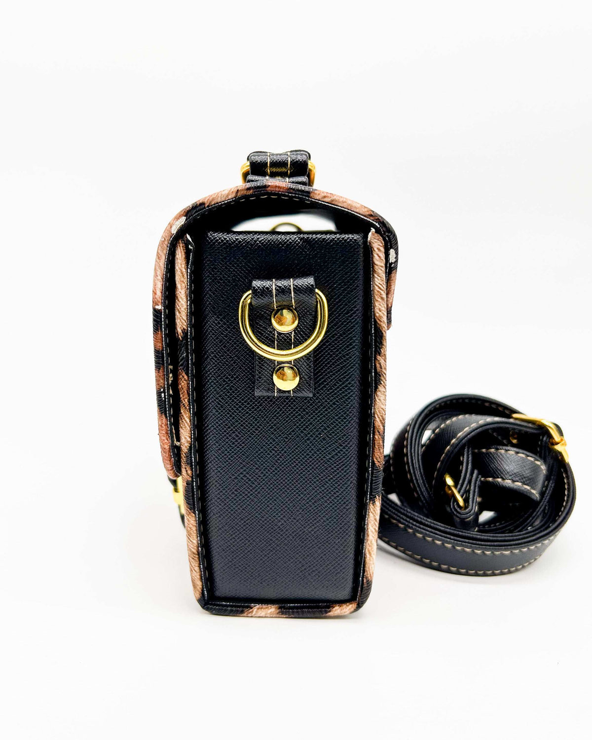 Side view, brown and black leopard print vegan leather handbag, backpack or crossbody bag with two gold buckled clasps.
