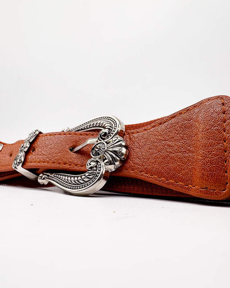 Brown leather belt with a silver buckle on a white background