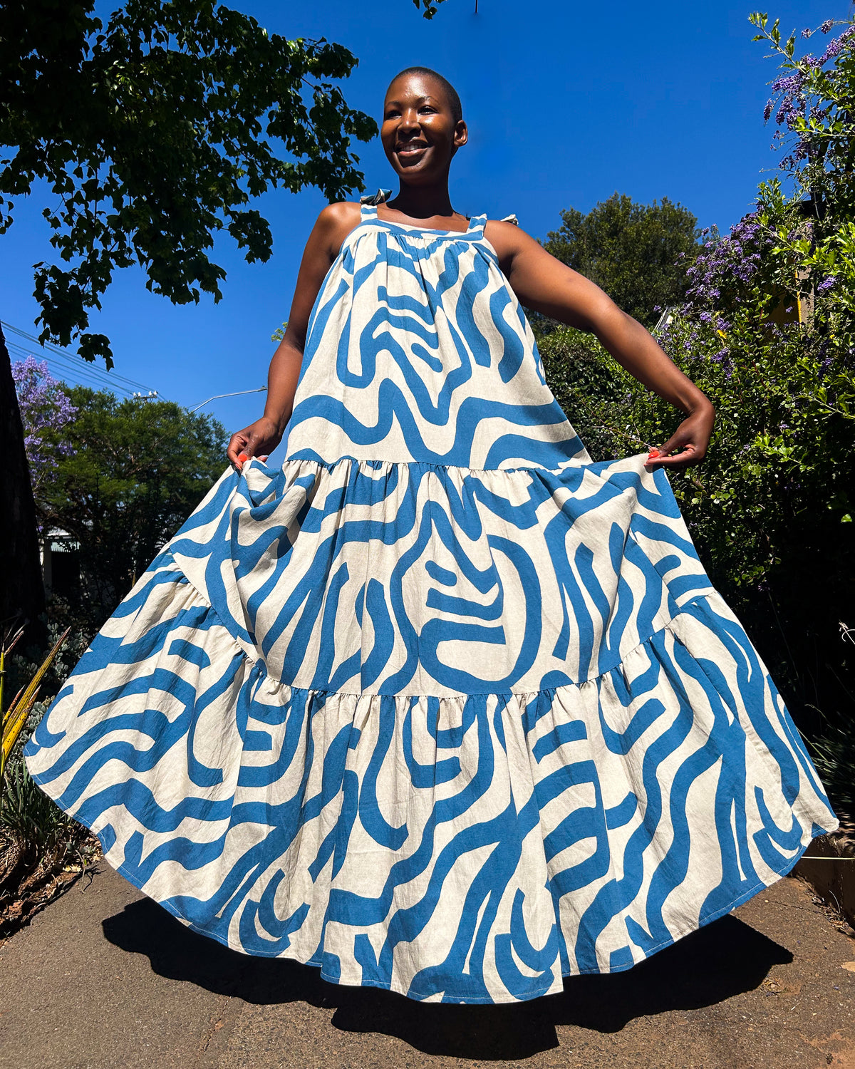 African woman wearing a Ranji Dress in blue and white.