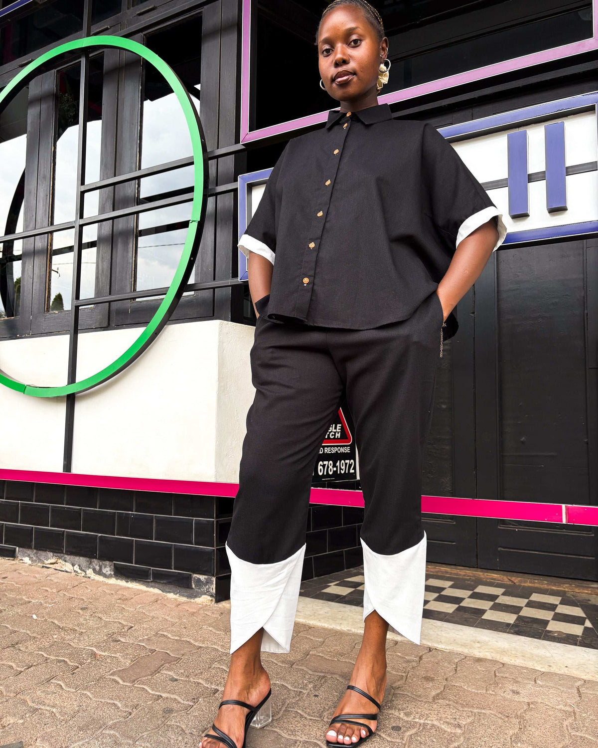 African woman wearing Dr Pachanga two-tone Kate Pants in black and white, with hands in her pockets.