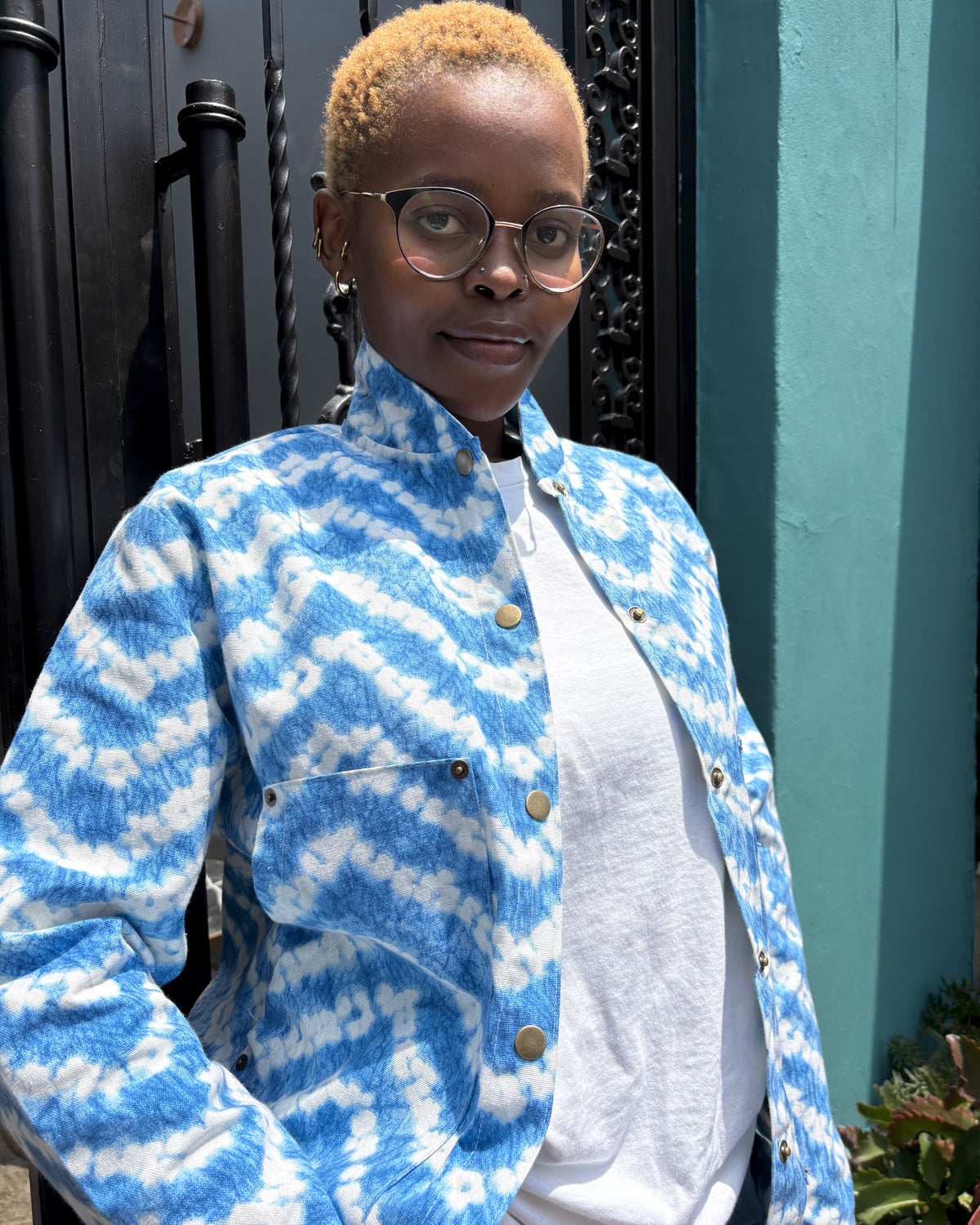 African woman wearing an unbuttoned sky-coloured Miguel Jacket. 