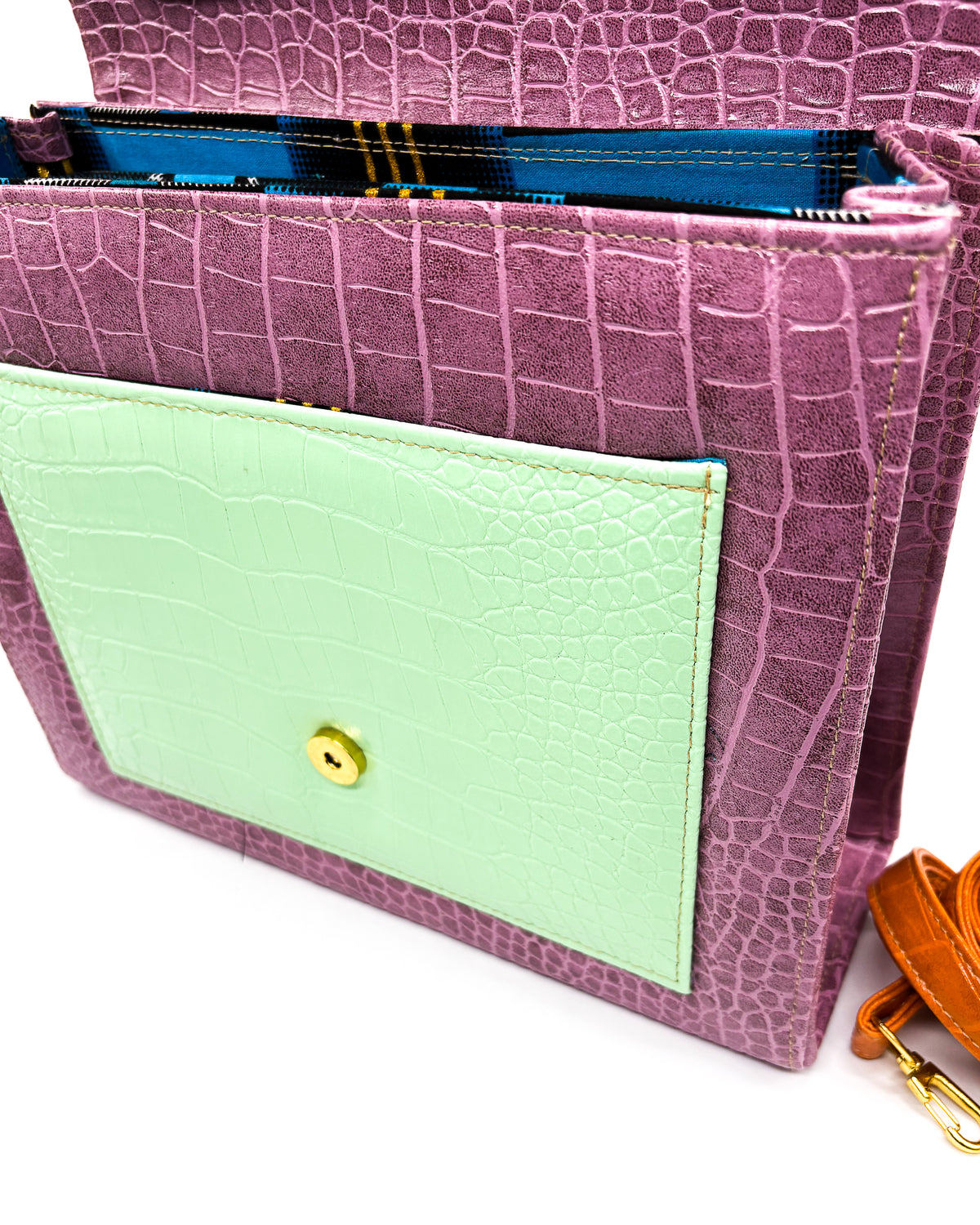 Open view, purple, green and animal print vegan leather handbag, crossbody or backpack with African wax fabric accent, a gold buckle and a magnetic clasp.