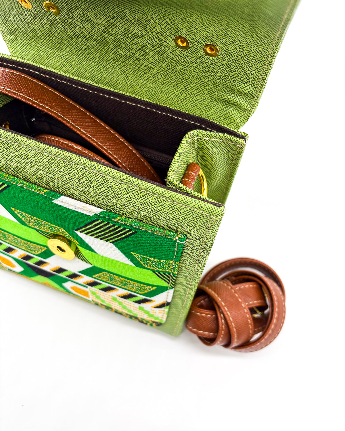 Inside view, green vegan leather handbag or crossbody bag with colouful African wax fabric inlay, and a gold magnetic clasp.