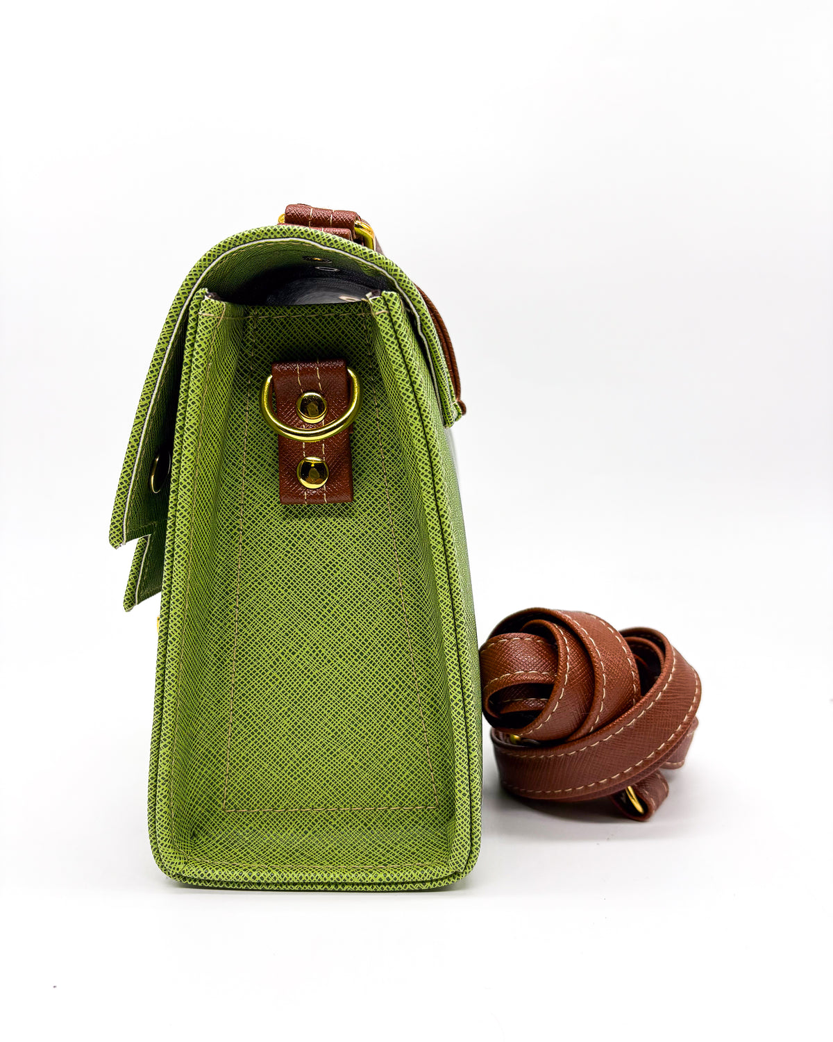 Side view, green vegan leather handbag or crossbody bag with colouful African wax fabric inlay, and a gold magnetic clasp.