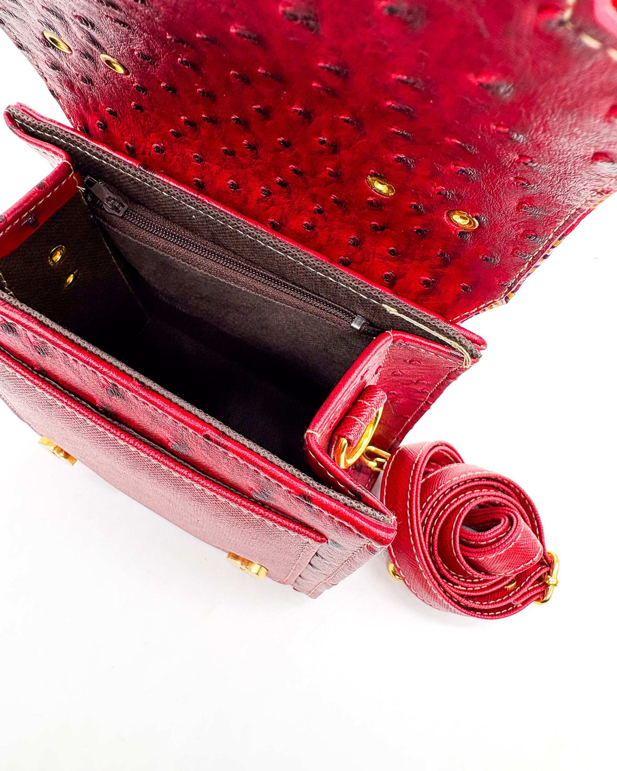 Open maroon vegan leather handbag or crossbody bag with red and gold African Wax fabric inlay, two gold buckles and magnetic clasp.