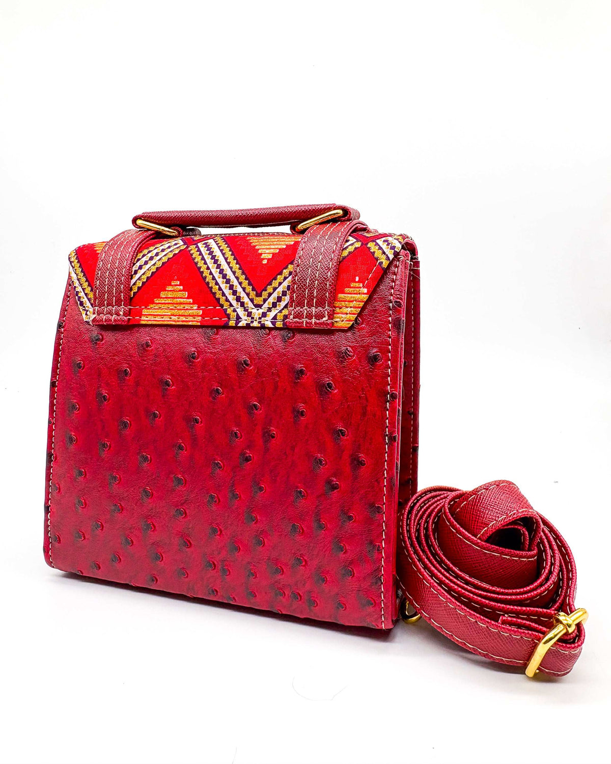 Back view, maroon vegan leather handbag or crossbody bag with red and gold African Wax fabric inlay, two gold buckles and magnetic clasp.