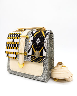 Grey and beige vegan leather handbag or crossbody bag with black and gold African wax fabric inlay, and a gold magnetic clasp.