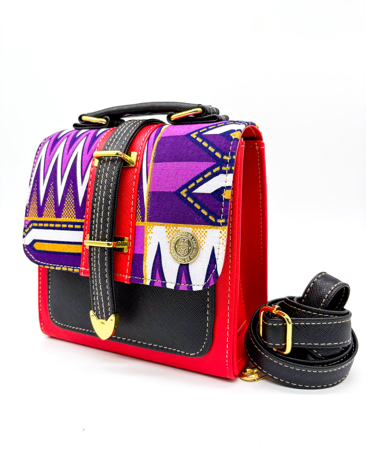 Black and electric red vegan leather handbag or crossbody bag with purple and yellow African wax fabric inlay, and a gold magnetic clasp.