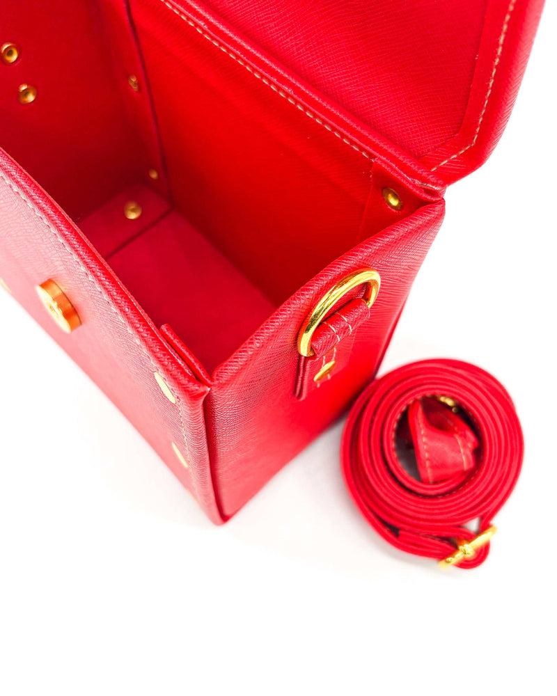 Inside view, red vegan leather handbag or crossbody bag, with red, gold and white African Wax fabric inlay, a gold buckle and magnetic clasp.