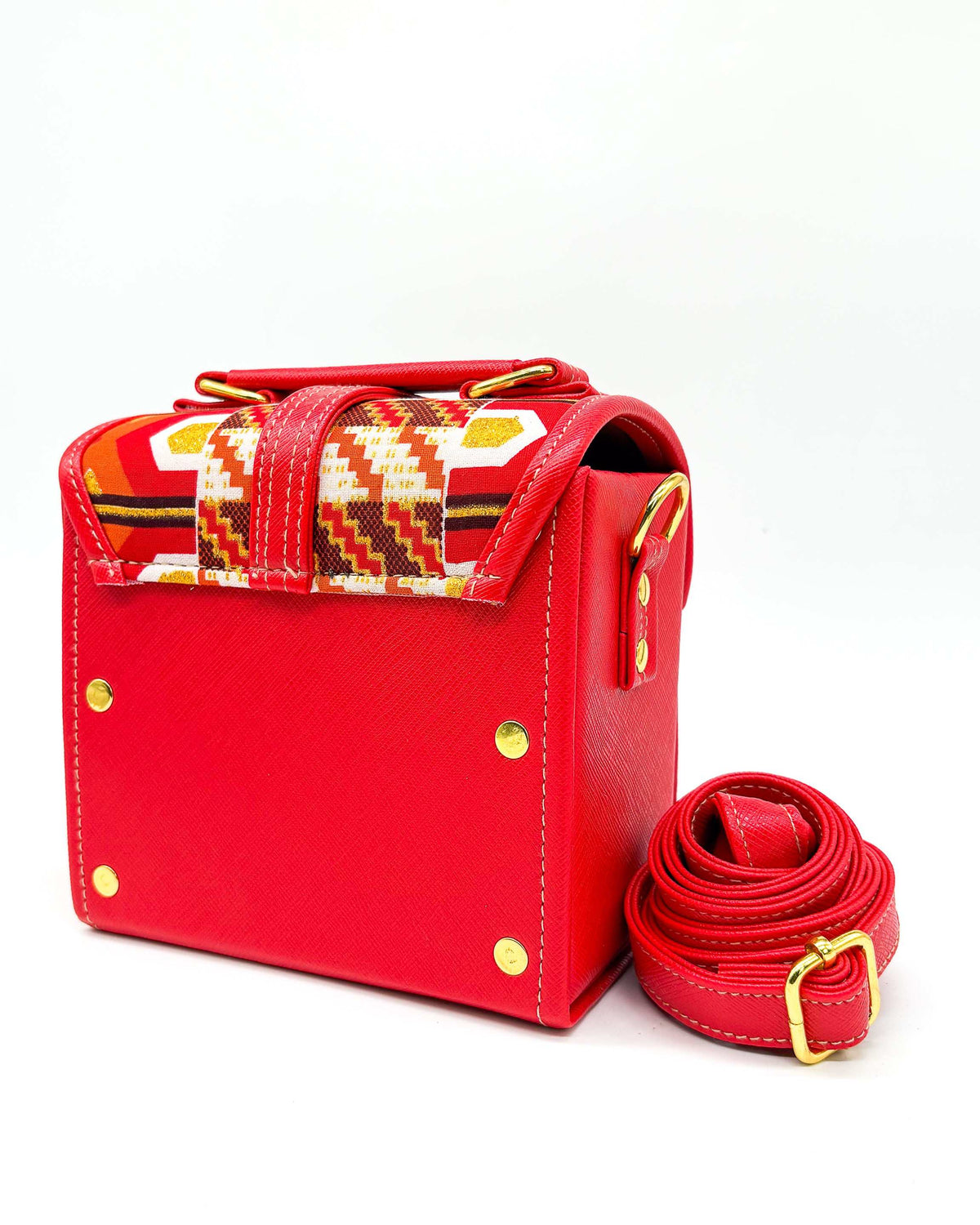 Back view, red vegan leather handbag or crossbody bag, with red, gold and white African Wax fabric inlay, a gold buckle and magnetic clasp.