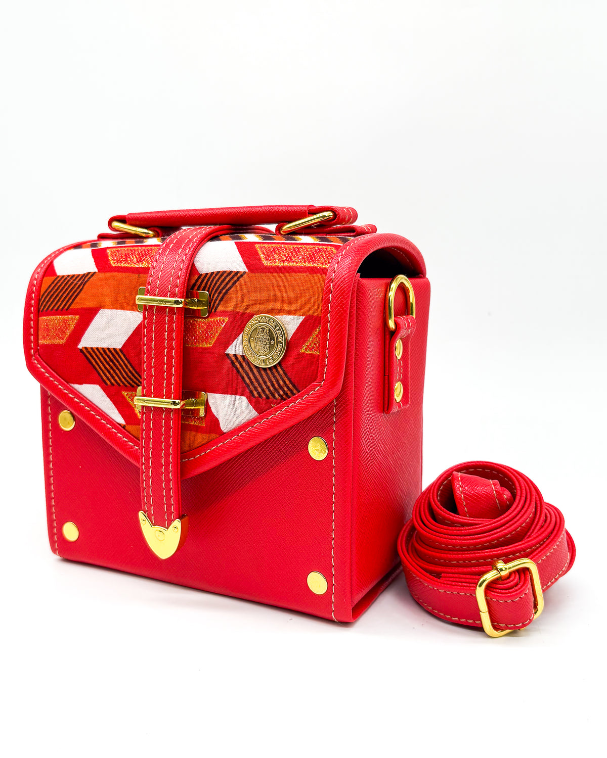 Electric red vegan leather handbag or crossbody bag, with red, gold and white African Wax fabric inlay, a gold buckle and magnetic clasp.