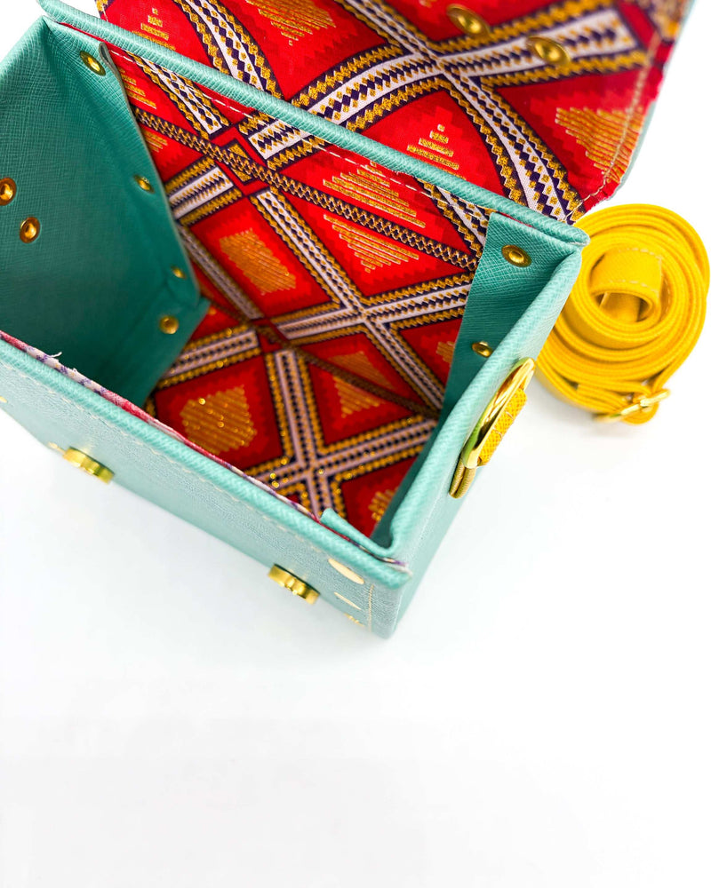 Inside view, teal vegan leather handbag or crossbody bag with African wax fabric interior lining, two gold buckles and a magnetic clasp.