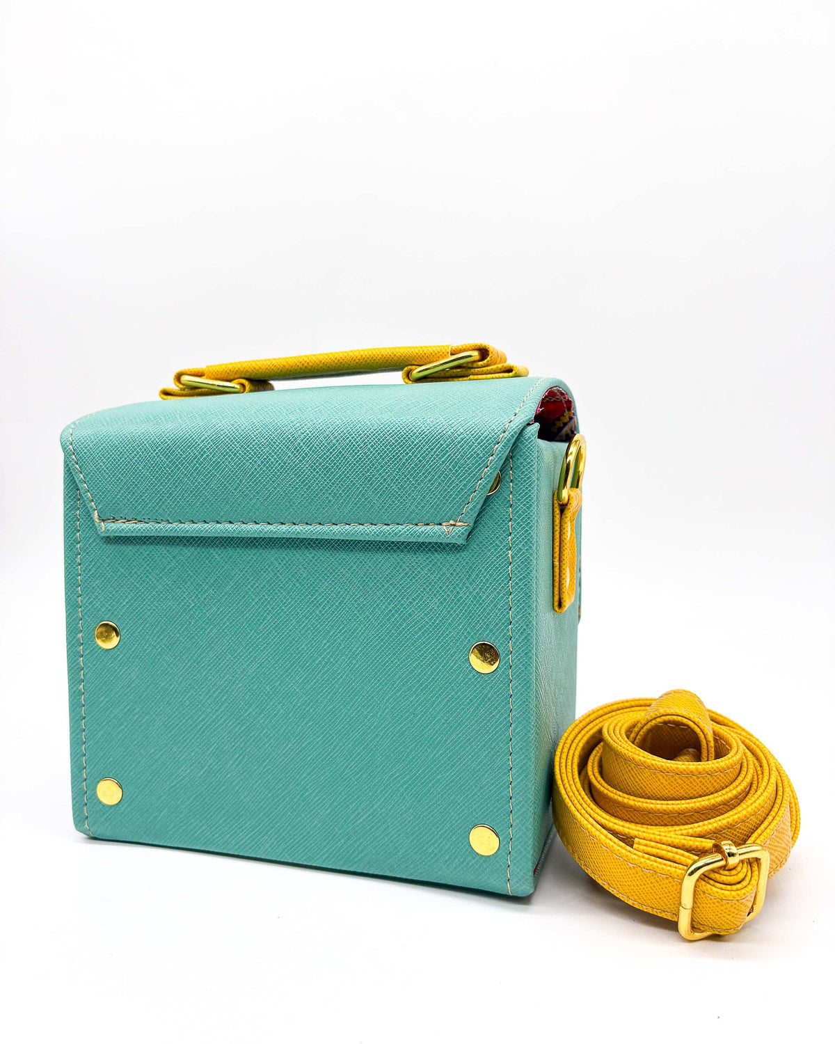 Back view, teal vegan leather handbag or crossbody bag with African wax fabric interior lining, two gold buckles and a magnetic clasp.