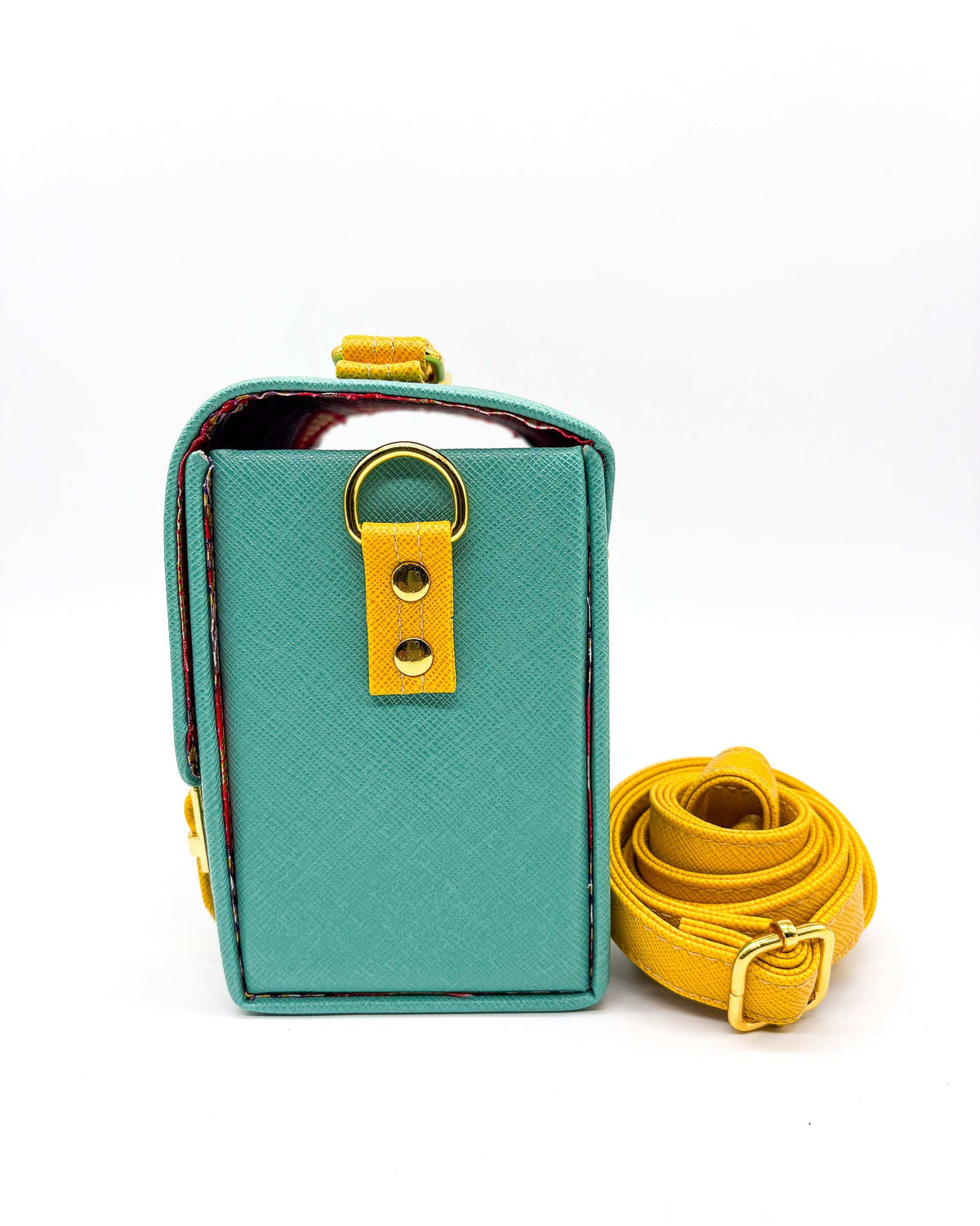 Side view, teal vegan leather handbag or crossbody bag with African wax fabric interior lining, two gold buckles and a magnetic clasp.