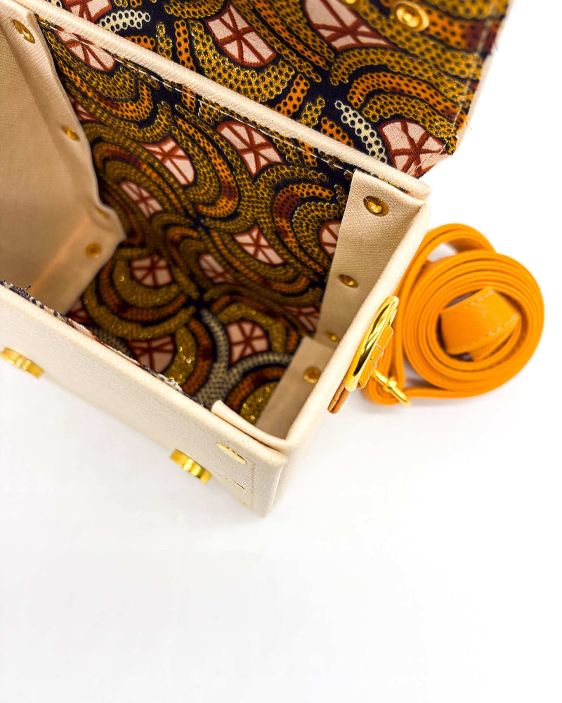 Inside view, off white vegan leather handbag or crossbody bag with African wax fabric interior lining, two gold buckles and a magnetic clasp.