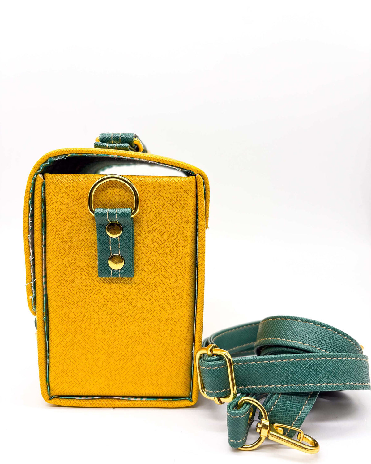 Side view, yellow and green vegan leather handbag or crossbody bag with African wax fabric interior lining, two gold buckles and a magnetic clasp.