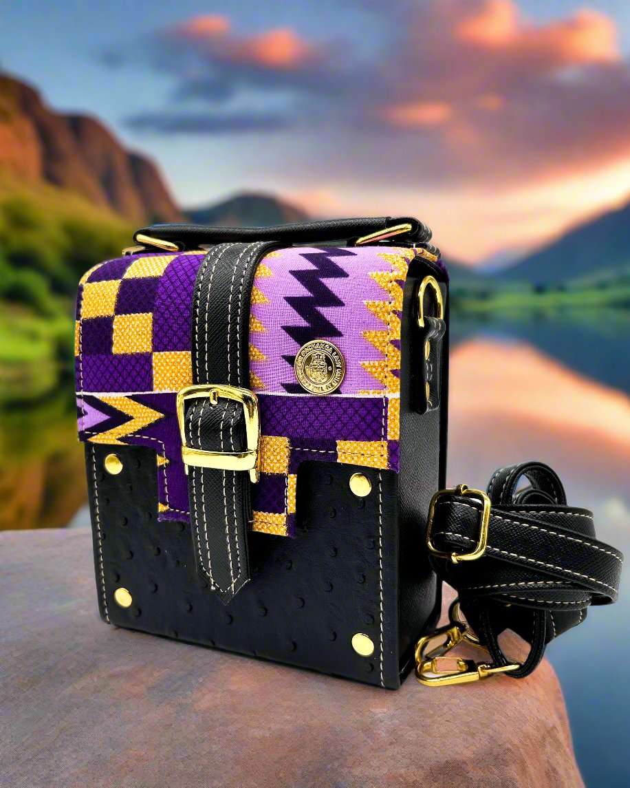 Nature setting, black vegan leather handbag with yellow and purple African Gold Wax fabric inlay, a single gold buckle, magnetic clasp and adjustable strap.